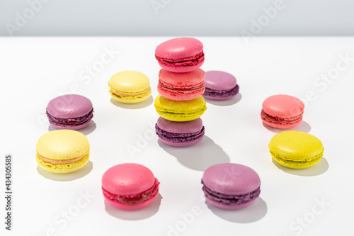 colorful macaroni cakes stacked in a tower and a circle on a white background