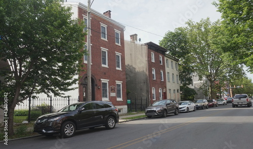 Row Home or Townhouse Style Brick and Stucco Offices Street with Cars Some Windows with Plywood