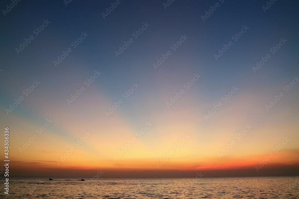 Ray of sunlight, crepuscular rays, in summer time with the clouds, the sea, and the island. Low key. Nature background concept.