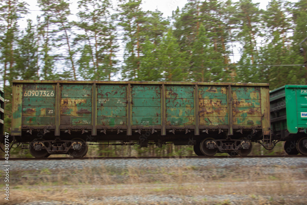 A gondola car as part of a train. A gondola car as part of a freight train rushes along the rails.
