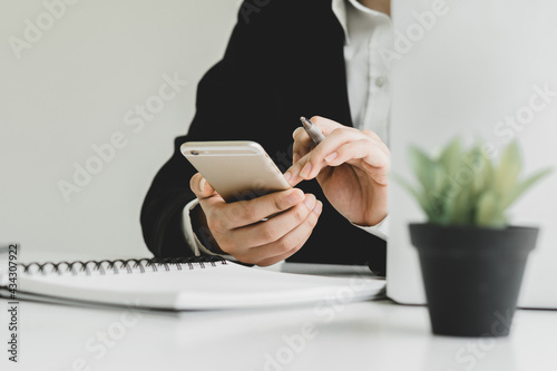 Work from home concept. man in casual wear using mobile phone during online working on laptop computer from home