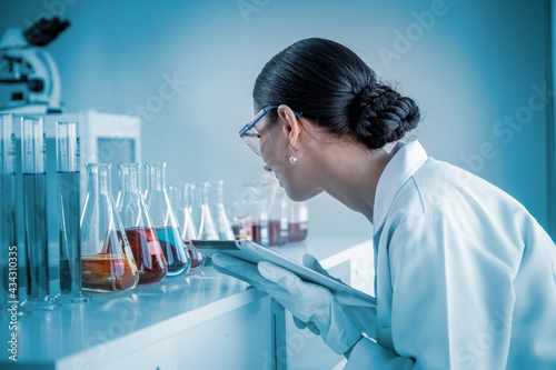 Scientist wearing uniform and glass holding test tube in laboratory research and development concept for industry or hospital photo