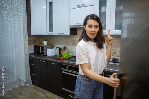 woman opened fridge thinking what to cook