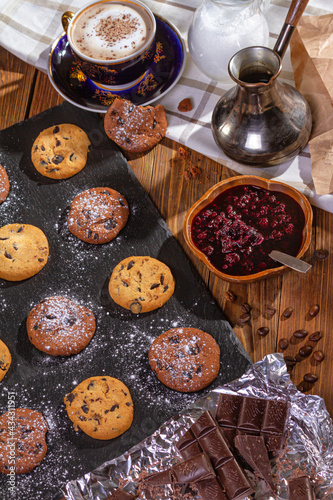 Cookies with chocolate, jam and coffee on a wooden table, flat lay, top view