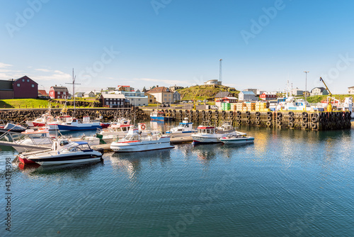 Traditional harbour village in northern iceland on a clear summer morning. Boats moored to jetties are in foreground. Stykkishólmur, Iceland.