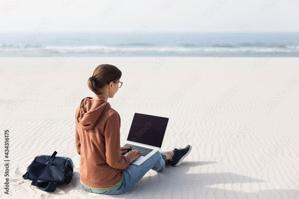Woman using laptop computer on a beach. Freelance work, vacations, business, people, technologies, distance studying, e-learning, connection, social distancing, communication online concept