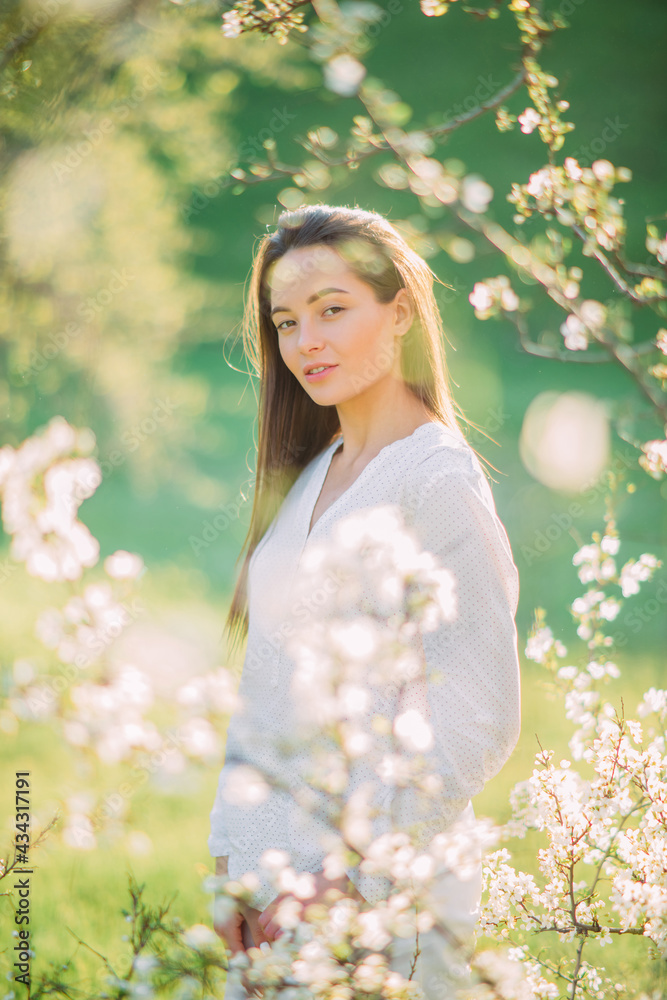 Young woman enjoys among the blossoming cherry trees. Young woman enjoys among the blossoming cherry trees.
