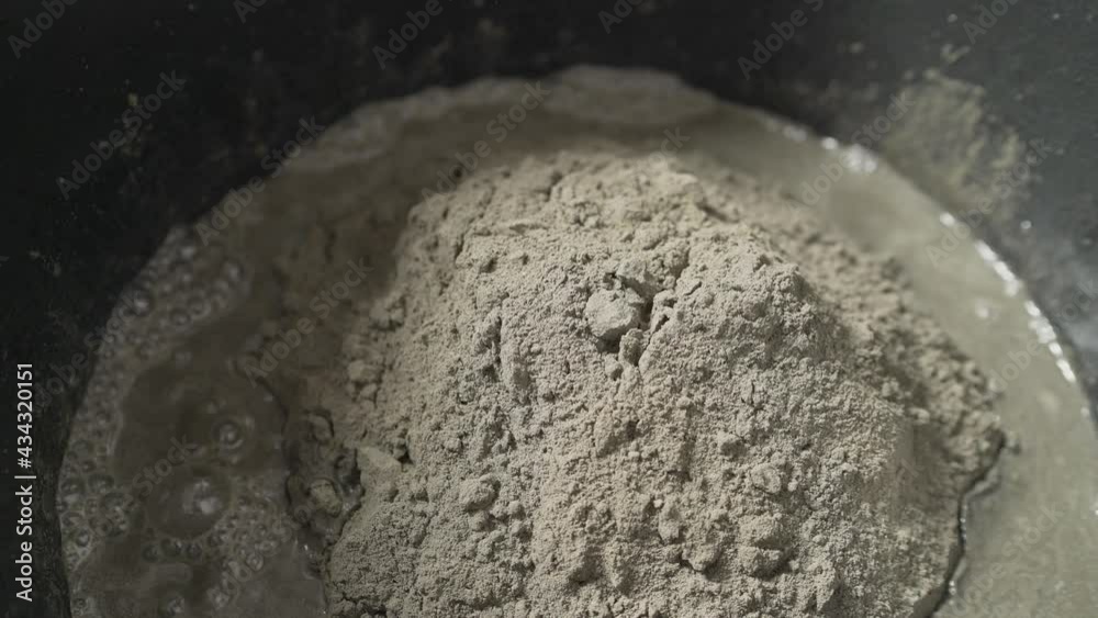 The building mixture is added to the mixing bucket. Adding hardener to micro concrete plaster.
