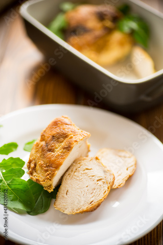 baked chicken fillet pieces with spices and herbs, in a ceramic form