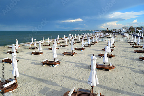 empty beach chairs and umbrellas after opening time (in the evening) - Navodari, Constanta, Dobrudja, Romania, Europe, Black Sea photo