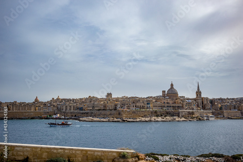 Elevated view of the amazing old city of Valletta, capital of Malta and the bay with boats, scenery cloudy sky in a sunny spring day
