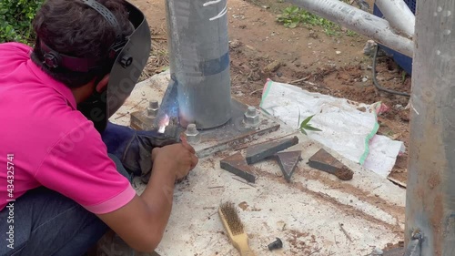 Amateur blacksmiths work with welding machines to weld steel frames and to train their skills of welding,Blue fire flickers, orange sparks are flying.