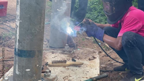 Amateur blacksmiths work with welding machines to weld steel frames and to train their skills of welding,Blue fire flickers, orange sparks are flying.