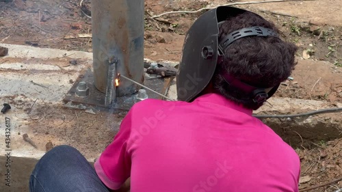Amateur blacksmiths work with welding machines to weld steel frames and to train their skills of welding,Blue fire flickers, orange sparks are flying.