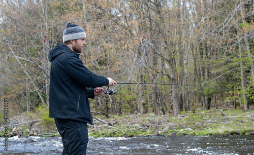 Man shore fishing in fresh water, during early spring