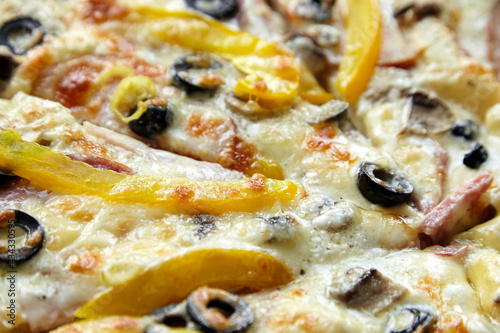 Pizza slices with chesse, ham, yellow bell pepper, olives and mushrooms, background , closeup