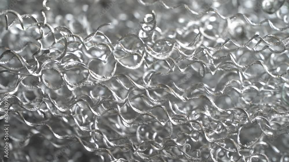 Aluminum chip waste after machining metal parts on a cnc lathe. Closeup twisted spiral steel shavings. Aluminum chip waste after machining metal parts on a cnc lathe. Closeup twisted spiral steel shavings.