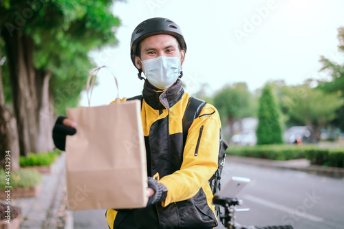 Anonymous fast delivery food service at home. Man courier delivered the order bag with food.
