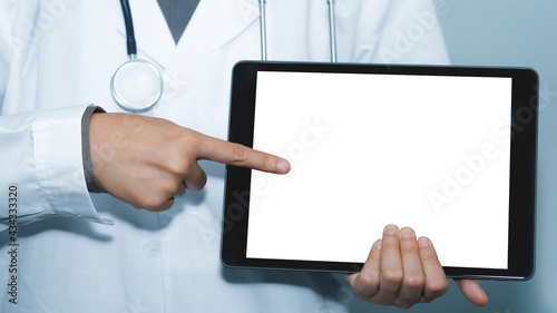 Doctor standing in clinic and using tablet pc, hospital office for professional emergency healthcare assistance service concept, Doctor online, Online medical communication.