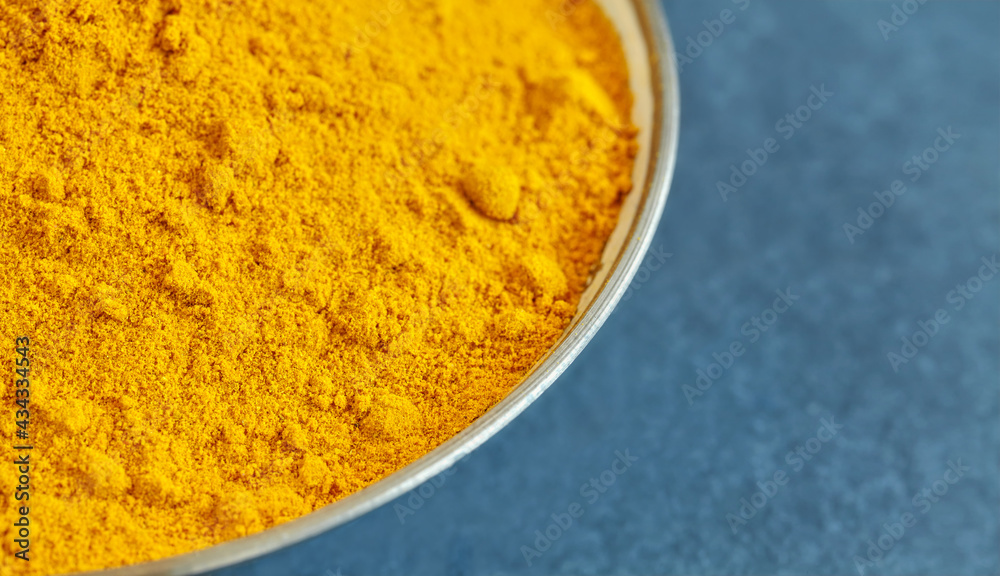 Close up picture of turmeric powder in a bowl, shallow depth of field, space for text. Close up picture of turmeric powder in a bowl, shallow depth of field, space for text.