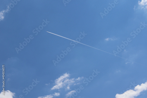A jet forming contrails in a blue sky. Airplane fly with condensation trail.