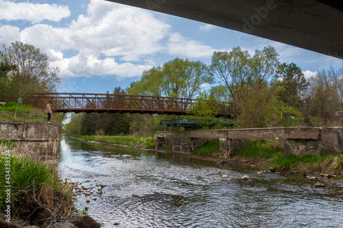 A man stands at the edge of a historic would-be canal and admires the swing bridge that never saw use as the canal project was canceled in the early 1900s, in Newmarket, Ontario. photo