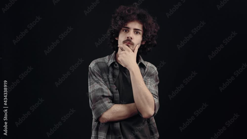 The portrait of a hipster thinking with his hand on his chin, he analyzes, he gets an idea that makes him very happy, he looks like. Isolated on black background, Concept of life. People's emotions The portrait of a hipster thinking with his hand on his chin, he analyzes, he gets an idea that makes him very happy, he looks like. Isolated on black background, Concept of life. People's emotions