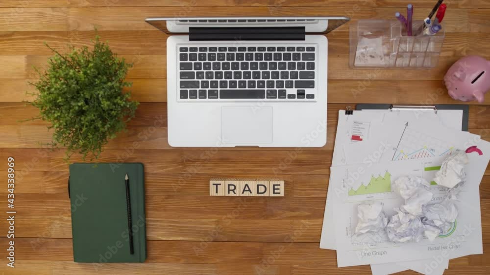 Word trade is made of cubes on an office table with notebook and documents. Word trade is collected from wooden cubes. Concept of marketing and business. Word trade is made of cubes on an office table with notebook and documents. Word trade is collected from wooden cubes. Concept of marketing and business.