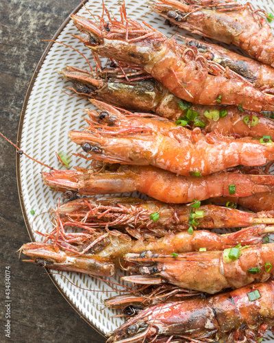 Grilled shrimps on a plate with spring onions