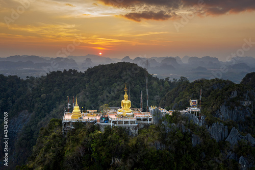 Aerial view from drone of "Wat Tham Suea" (The Tiger Cave temple) during sunset well-known temple on a hilltop in Krabi, Thailand. © Gosgrapher