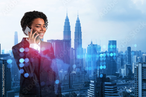 Attractive black woman new approaches to protect clients confidential information using phone. IT social network icons over Kuala Lumpur city background.