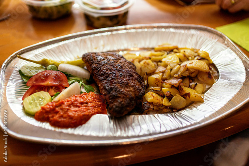 Food to go: stuffed meatloaf with broad potatoes, onions an ajvar on an aluminium dish