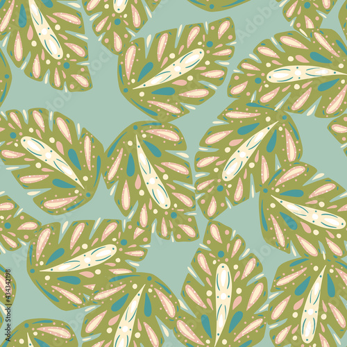 Random green folk monstera print seamless pattern. Blue background. Bloom tropic foliage ornament.