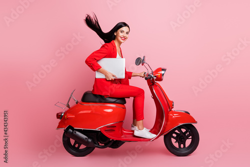 Full length profile side photo of young girl happy smile hold laptop ride bike meeting isolated over pink color background