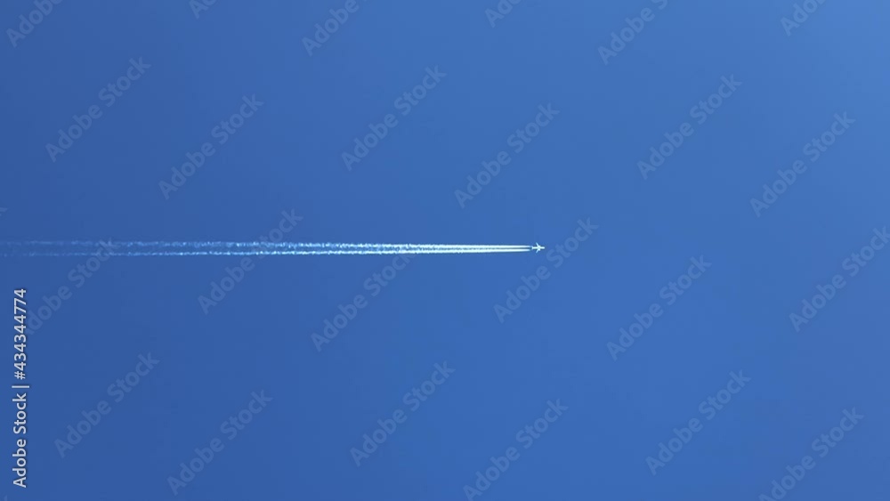 Jet aeroplane flying directly overhead with vapor trails  