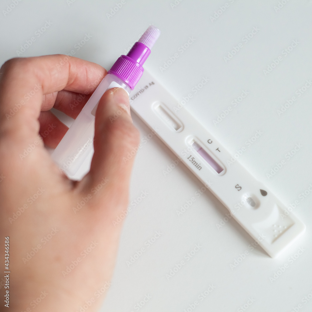 close up of hand, person using swab test covid-19, antigentest, self test kit on the white table close up of hand, person using swab test covid-19, antigentest, self test kit on the white table