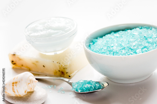 Home cosmetic with cream and blue sea salt on white background