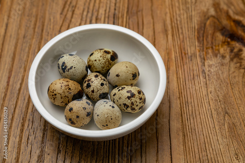 quail eggs in a plate on a wooden table
