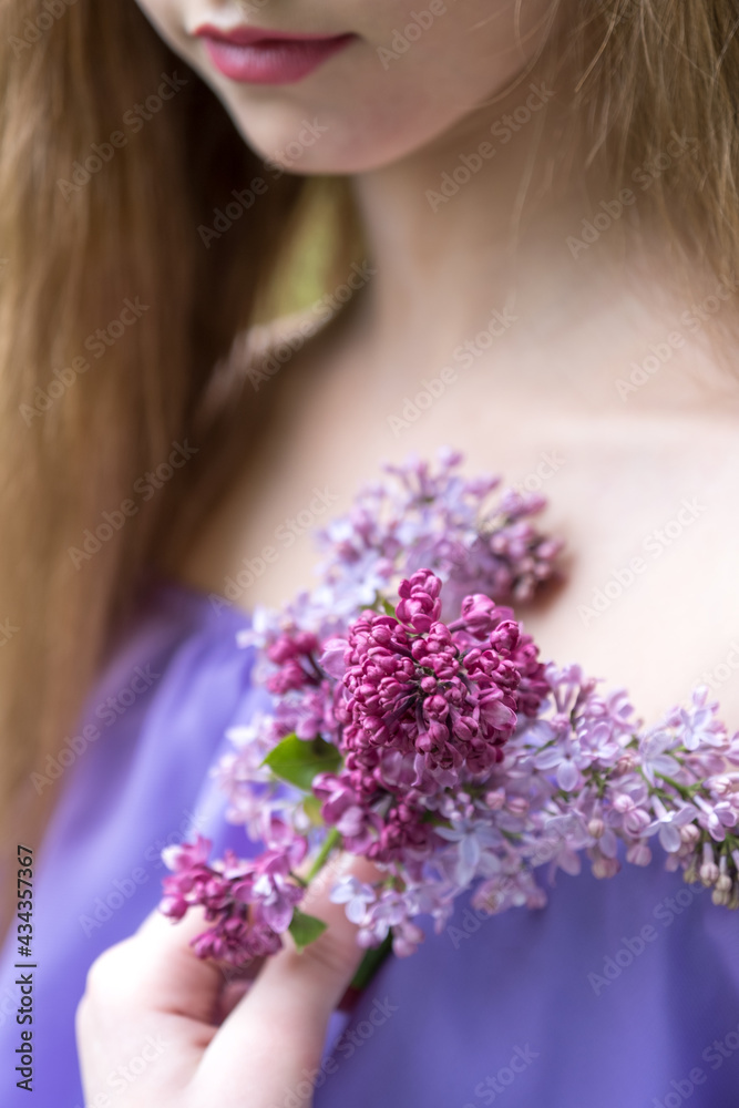 Girl with a bouquet of lilacs in the hand