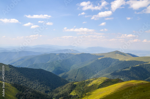Scenic view to valley with grassy slope and forested hills on fine summer day. Carpathian Mountains. Ukraine  © Dmytro