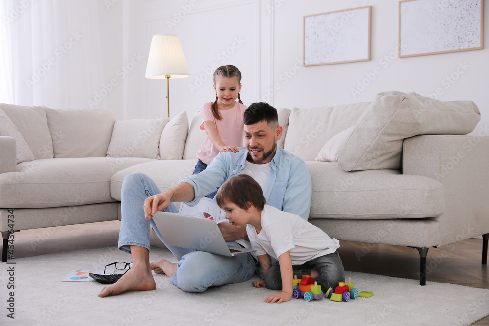 Overwhelmed man combining parenting and work at home Overwhelmed man combining parenting and work at home