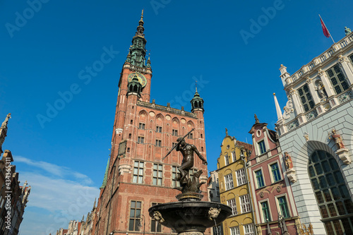 The Neptune's Fountain in Old Town of Gdansk, Poland. The fountain is located in the central point. Town Hall building in the back. City tour. Clear and bright day.