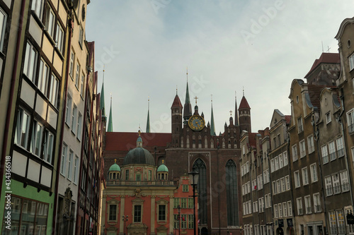 A close up of the facades of tall building in the middle of Old Town in Gdansk, Poland. The buildings have many bright colors, they are richly decorated. City tour. Clear day.