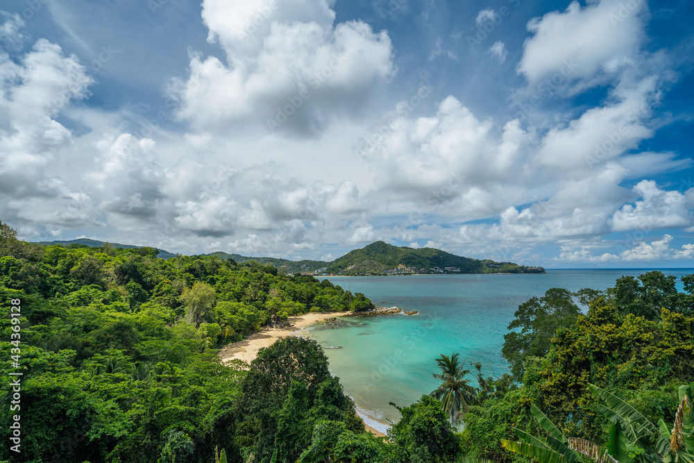 View from above of a cozy bay with turquoise sea and sandy beach surrounded by green hills