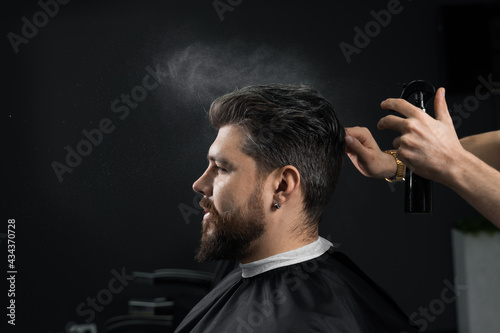 Barber making hairstyle for confident bearded hipster. Advertising for barbershop and men's beauty salon.