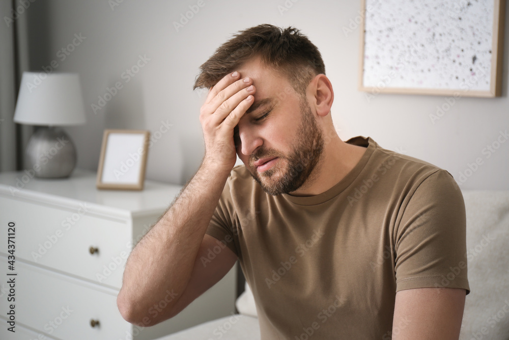 Young man suffering from migraine at home Young man suffering from migraine at home