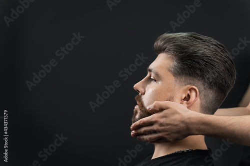 Fixing the shape of the beard with wax. The result of a haircut in a barbershop.