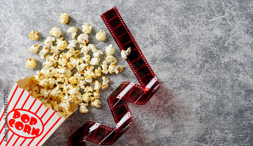 Fotografie Caramel popcorn in a paper cup on a Loft background, 35mm film laid flat