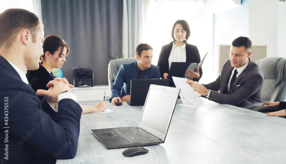 Group of young successful businessmen lawyers communicating together in a conference room while working on a project Group of young successful businessmen lawyers communicating together in a conference room while working on a project