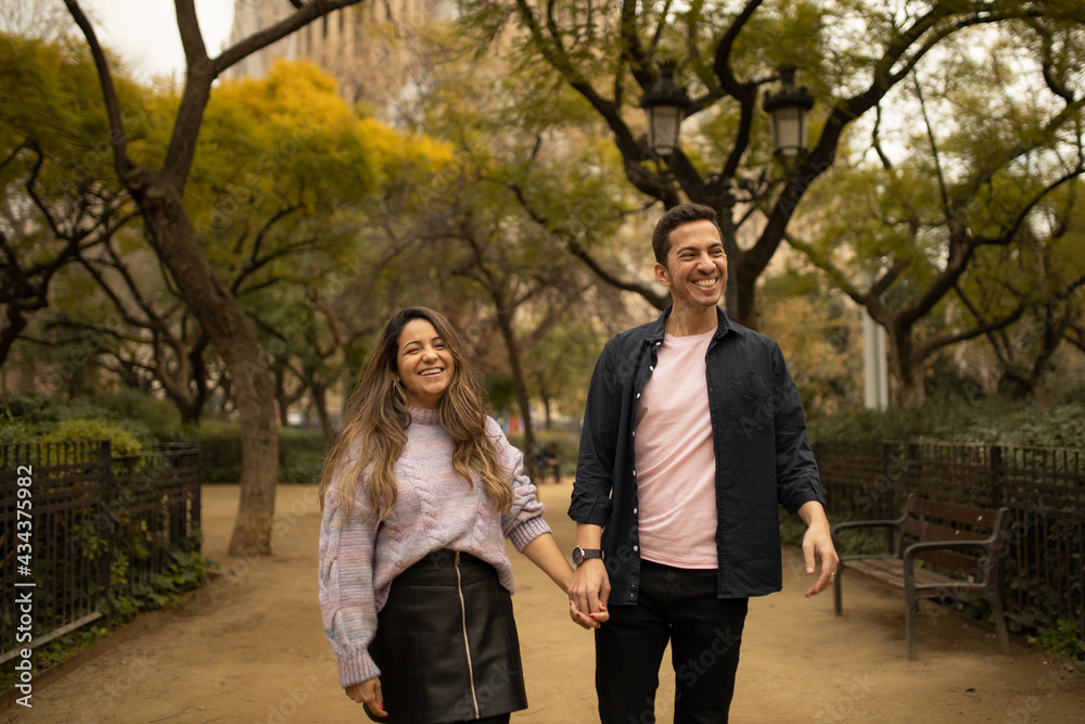A happy couple walking and smiling looking each other A happy couple walking and smiling looking each other